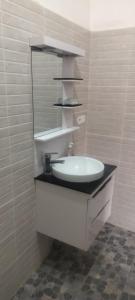 a bathroom with a sink and a mirror at Chez Roseline in Ndangane