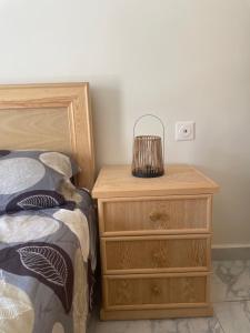 a bedroom with a bed and a nightstand with a lamp at Appartement climatisé avec balcon proche plage in Saïdia