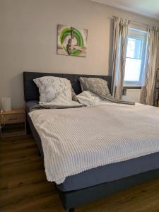 a bed sitting in a bedroom with a window at Pfoten & Komfort Barrierefrei in Butjadingen