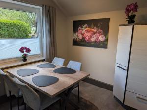 a room with a table with chairs and a window at Pfoten & Komfort Barrierefrei in Butjadingen