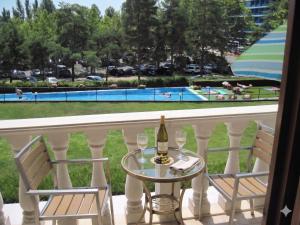 a table with a bottle of wine and two chairs on a balcony at Furedi Apartman in Balatonfüred