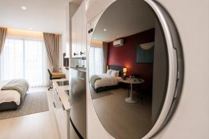 a hotel room with a mirror and a bedroom at Centraltique Veranda Living in Hanoi
