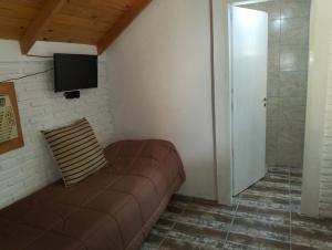 a living room with a couch and a television at Hosteria Atelier in Tigre