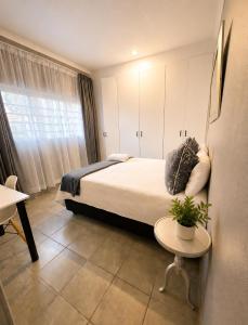 a bedroom with a bed and a table with a potted plant at Zhantique Guest House 2- Unit 6 in Boksburg