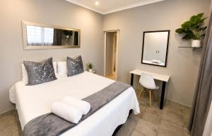 a bedroom with a bed with a mirror and a desk at Zhantique Guest House 2- Unit 6 in Boksburg +14 photos