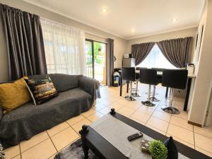 a living room with a couch and a piano at Zhantique Guest House 2- Unit 6 in Boksburg