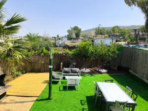 a garden with a table and chairs on the grass at Domos Tiberias - Heated pool דומוס טבריה- בריכה מחוממת דקת הליכה לממד in Tiberias