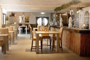 a restaurant with a table and chairs and a bar at Camping Groene Eiland in Appeltern