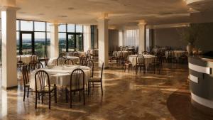a dining room with white tables and chairs at Aia del vento in Cisternino