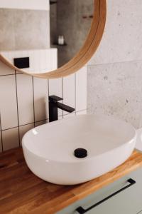 a bathroom with a white sink and a mirror at Apartamenty Wrzosowa 23 z garażem na rowery in Kudowa-Zdrój