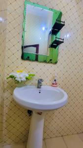 a bathroom sink with a mirror on the wall at WamkHouse in Jambiani +19 photos