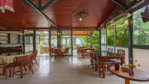 a restaurant with tables and chairs and windows at Flower Hotel Patara in Patara