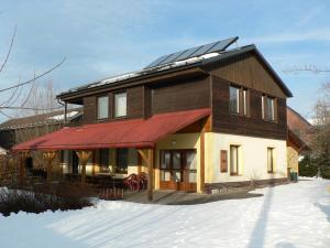 une maison avec des panneaux solaires sur le toit dans la neige dans l'établissement Chata Pod Hájkem, à Vrchlabí