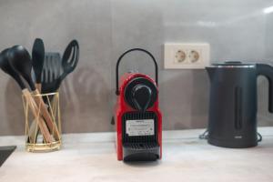 a red blender sitting on a counter with utensils at Unique Kos Apartment in Ampavris