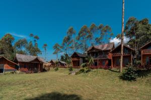 a group of wooden houses with trees in the background at TB Villa Resort By ARBA in Palayangan