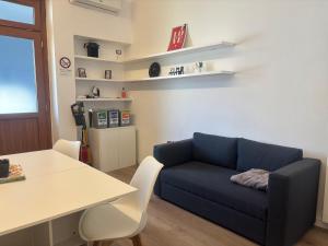 a living room with a blue couch and a table at Milano side house apartment in Sesto San Giovanni