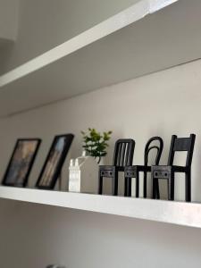 two black chairs sitting on a shelf with pictures at Milano side house apartment in Sesto San Giovanni