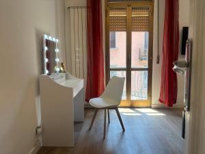 a white desk and a chair in a room with a window at Milano side house apartment in Sesto San Giovanni