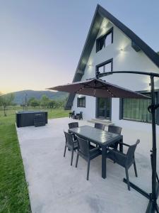 a patio with a table and chairs and an umbrella at Sunny Hill Cab in Bulz