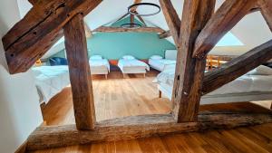 a attic room with two beds and a ceiling with beams at La Valdonnière in Esnoms-au-Val