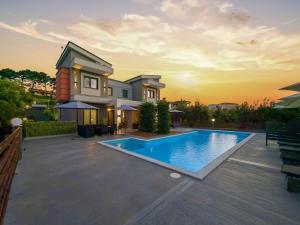 a villa with a swimming pool at sunset at Assos Luxury Villas in Pefkochori