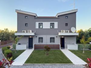 a large white house with a yard at Assos Luxury Villas in Pefkochori
