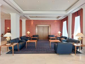 a waiting room with blue couches and tables at Hotel Olympia Palace in Olympia
