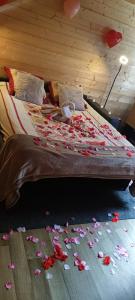 a bed with flowers on the floor in a room at Le Chalet de Gaby in Vinnemerville