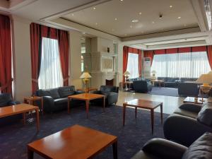 a living room with couches and tables and windows at Hotel Olympia Palace in Olympia +18 photos