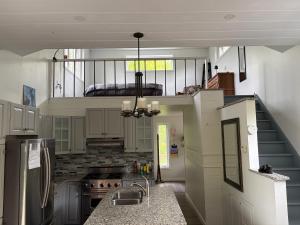 a large kitchen with a sink and a staircase at Hidden Getaway in Pembroke