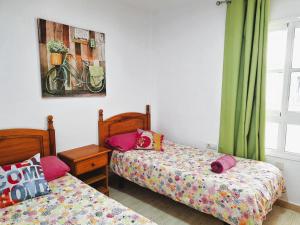 a bedroom with two beds and a picture of a bike at Casa Deborah in Callao Salvaje +17 photos