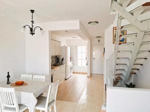 a kitchen and dining room with a table and a spiral staircase at Casa Deborah in Callao Salvaje