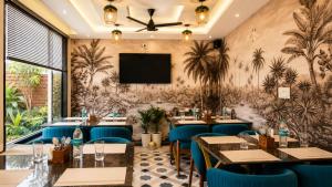 a restaurant with tables and chairs and a flat screen tv at Hotel The Montara Near Ganga Ghat in Rishīkesh +40 photos