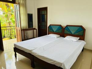 a bedroom with a large bed with white sheets at Cloud Nine in Diyatalawa
