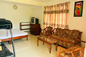 a living room with a couch and a tv at Cloud Nine in Diyatalawa