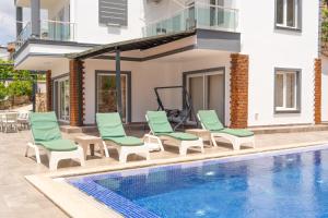 a group of chairs and a swimming pool at Villa Mevsim in Kaş