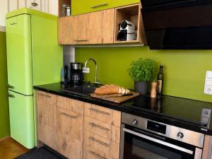 a kitchen with green walls and a black counter top at Appartment im Villenviertel in Jena
