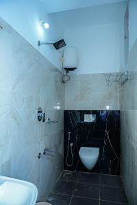 a bathroom with a white toilet and a sink at Coorg Manam Homestay in Kushālnagar