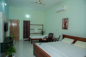 a bedroom with a bed and a desk and a chair at Coorg Manam Homestay in Kushālnagar