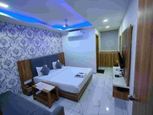 a bedroom with a bed and a tv and a couch at HOTEL ROCK In in Anand