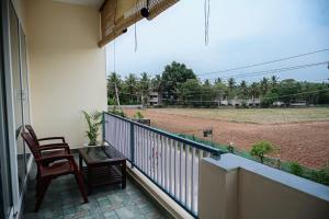 a balcony with two chairs and a baseball field at Coorg Manam Homestay in Kushālnagar +3 photos