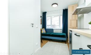 a kitchen with a blue bench in front of a window at Sõle Studios by RevalHome in Tallinn +4 photos