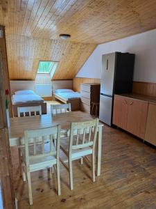 a room with a table and chairs and a refrigerator at Apartment sklep 33E in Hrušky