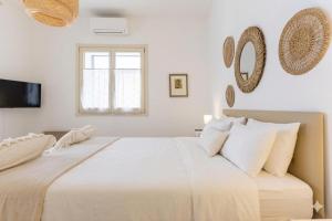 a white bedroom with a large bed with white pillows at la perla sul mare in Sampieri