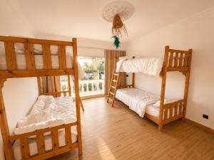 a room with two bunk beds and a window at Happy Waves Morocco - Surf Hostel Tamraght in Tamraght Ou Fella