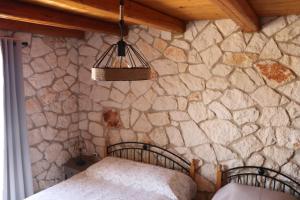a bedroom with a stone wall with a bed at Villa Socrates in Vasilikos