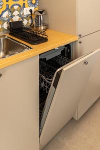 a kitchen with an open dishwasher next to a sink at la perla sul mare in Sampieri +12 photos