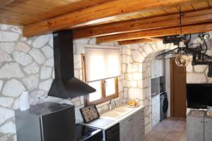a kitchen with a stove and a stone wall at Villa Socrates in Vasilikos