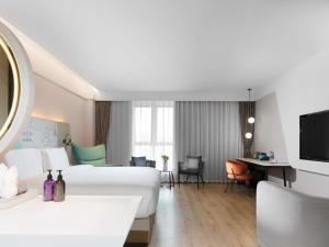 a hotel room with a bed and a desk at Mercure Chengdu Xindu in Chengdu +39 photos