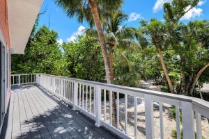 a porch with a white railing and palm trees at Pink Shell Sanibel in Sanibel +18 photos